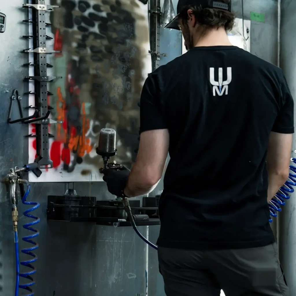 Cerakote technician sprays a test spray before coating a rifle.